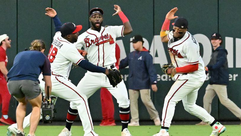 Braves outfielders (from left) Guillermo Heredia, Michael Harris II and Ronald Acuna celebrate their 5-3 victory over the Mets at Truist Park on Sunday, Oct. 2, 2022.  (Hyosub Shin / Hyosub.Shin@ajc.com)
