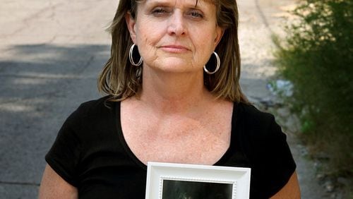 Robin Elliott holds a photograph of her late 21-year-old son, Zack Elliott, who was found dead in his automobile of a drug overdose in 2011. (AJC File Photo)