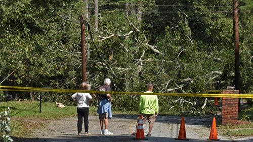 Residents watch over a huge fallen tree that caused the loss of the power in the neighborhood on Old Norcross Road in Tucker following Tropical Storm Irma, which swept across the metro area last week. Between 400 and 500 tons of debris related to the storm was brought to the DeKalb County landfill last week in just the initial stages of the cleanup. HYOSUB SHIN / HSHIN@AJC.COM