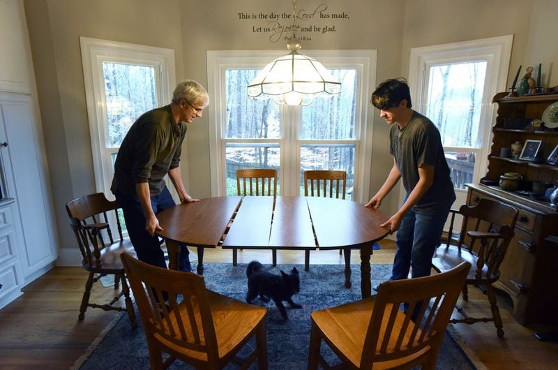 Tom Crittenden and his son, Mark, set up a table before they play a game of Rummikub at their home in Smyrna on a day in January. HYOSUB SHIN / HYOSUB.SHIN@AJC.COM