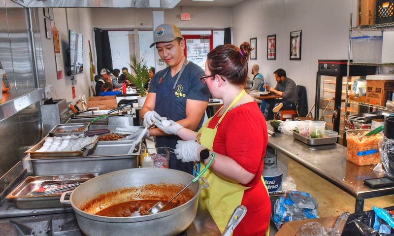 Mike Pimentel and Grace Wynn work in the kitchen just after opening the doors to Adobo ATL on a Sunday afternoon. (CHRIS HUNT FOR THE ATLANTA JOURNAL-CONSTITUTION)