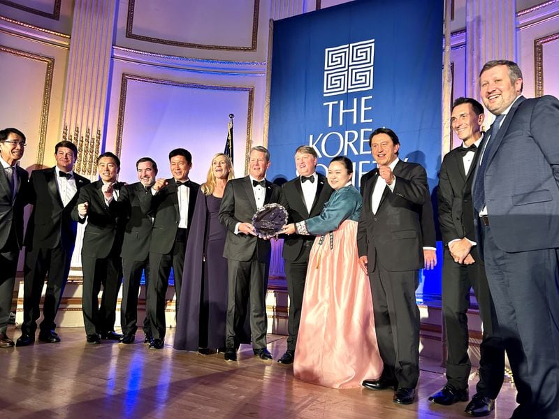 Gov. Brian Kemp, center, is joined by officials from the state, Hyundai Motor Group and other business and diplomatic officials at the annual Korea Society dinner. The state was honored with the Gen. James A. Van Fleet Award for its economic alliance with Korea. The governor will be in Texas today. (J. Scott Trubey/AJC)