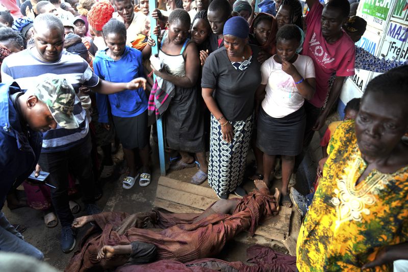 Residents gather around the covered dead body of a woman retrieved from a house, after heavy rain in the Mathare slum of Nairobi, Kenya, Wednesday, Apr. 24, 2024. Heavy rains pounding different parts of Kenya have led to the deaths of at least 35 people since mid-March and displaced more than 40,000 people, according to the U.N., which cites Red Cross figures in the most recent update. (AP Photo/Brian Inganga)