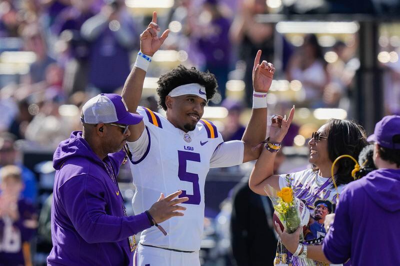 FILE - LSU quarterback Jayden Daniels (5) celebrates with his parents on senior day, for his final home game, before an NCAA college football game against Texas A&M in Baton Rouge, La., Saturday, Nov. 25, 2023. Daniels is a possible first round pick in the NFL Draft.(AP Photo/Gerald Herbert, File)