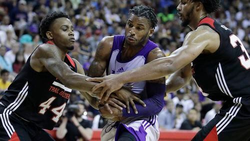 Los Angeles Lakers' Vander Blue, center, drives through Portland Trail Blazers' Antonius Cleveland, left, and Jarnell Stokes during the second half of the NBA summer league championship basketball game, Monday, July 17, 2017, in Las Vegas. (AP Photo/John Locher)
