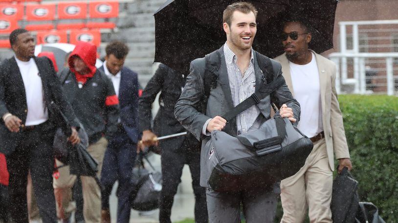 Georgia quarterback Jake Fromm is all smiles despite the wind and rain during the Dawg Walk.    Curtis Compton/ccompton@ajc.com
