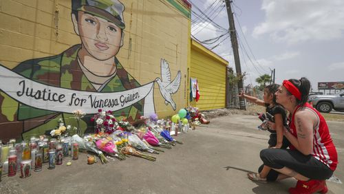 Dawn Gomez holds her 3-year-old granddaughter, Saryia Greer, who waves at Vanessa Guillen's mural painted by Alejandro "Donkeeboy" Roman Jr. on the side of Taqueria Del Sol, Thursday, July 2, 2020, in Houston. Army investigators believe Guillen, a Texas soldier missing since April, was killed by another soldier on the Texas base where they served, the attorney for the missing soldier's family said Thursday. (Steve Gonzales/Houston Chronicle via AP)