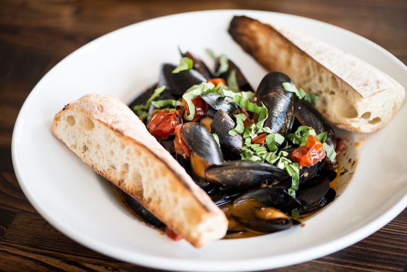 Rise & Revelry Mussels Small Plate with white wine, tomatoes, garlic, basil, and toasted baguette.