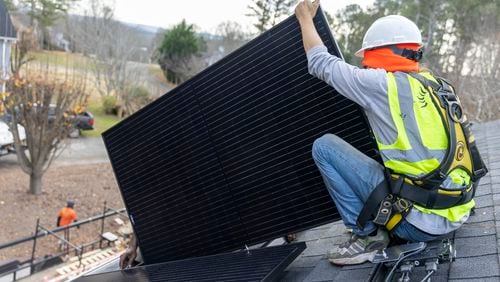 Joe McClain, an installer for Creative Solar USA, installs solar panels on a home in Ball Ground, Georgia on December 17th, 2021.  (Nathan Posner for The Atlanta Journal-Constitution)