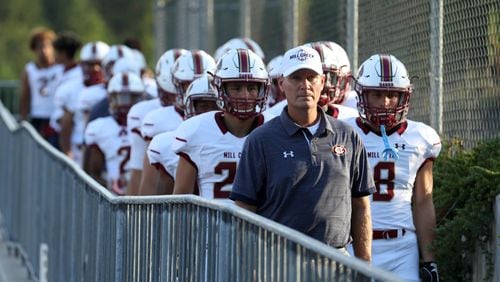 Former Mill Creek coach Shannon Jarvis leads his team to the field before a game against Archer. (Jason Getz/Special)