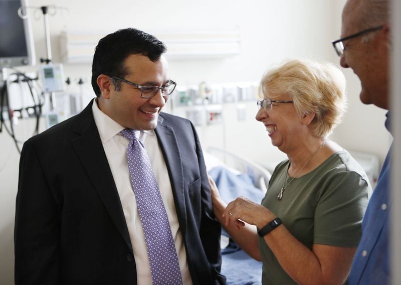    Dr. Aneesh Mehta (from left) speaks with Nancy Writebol and her husband, David, in the room in the Serious Communicable Diseases Unit where she was treated for Ebola in this August, 2, 2019 file photo. Mehta is an associate professor of medicine in Emory’s division of infectious diseases. 