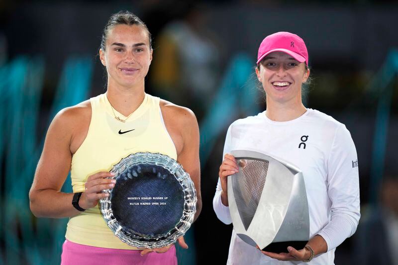 Winner Poland's Iga Swiatek, right, holds the trophy flanked by Aryna Sabalenka of Belarus after winning the women's final match against at the Mutua Madrid Open tennis tournament in Madrid, Spain, Saturday, May 4, 2024. (AP Photo/Bernat Armangue)