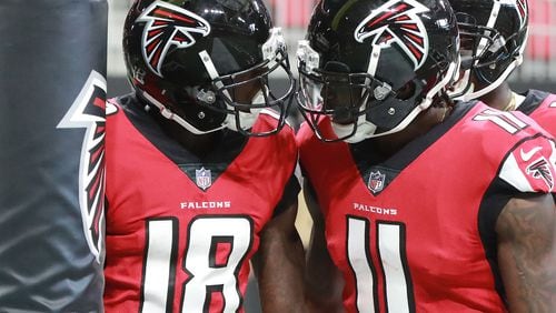 September 16, 2018 Atlanta: Falcons wide receiver Calvin Ridley gets a helmet bump from Julio Jones after his first NFL touchdown against the Panthers in a NFL football game on Sunday, Sept 16, 2018, in Atlanta.  Curtis Compton/ccompton@ajc.com