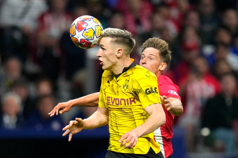 Dortmund's Nico Schlotterbeck, left, challenges for the ball with Atletico Madrid's Marcos Llorente during the Champions League quarterfinal soccer match between Atletico Madrid and Borussia Dortmund at the Metropolitano stadium in Madrid, Spain, Wednesday, April 10, 2024. (AP Photo/Manu Fernandez)