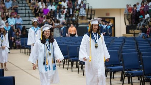 International Baccalaureate graduate Juanita Londono (left), shown at this year’s Marietta High School graduation, was a member of the National Honor Society, the Math Honor Society, the Beta Club and the Kitty Hawk Honor Society and was a varsity cross country and track athlete. CONTRIBUTED BY JOHNNY WALKER