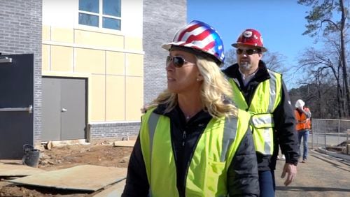 Marjorie Taylor Greene cultivated her image as a construction company owner and a conservative businesswoman in her bid for Congress. She is seen here in a campaign ad surveying a construction site with her husband, Perry, who is president of the company, Taylor Commercial, Inc. based in Alpharetta. (Campaign video image)