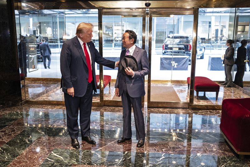 Republican presidential candidate former President Donald Trump greets former Japanese Prime Minister Taro Aso at Trump Tower in midtown Manhattan in New York, Tuesday, April 23, 2024. (AP Photo/Craig Ruttle)