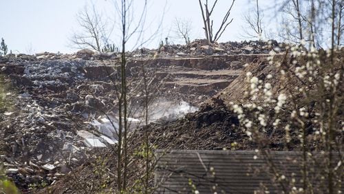 Smoke can be seen rising from piles of dirt and debris at an unlicensed landfill, located at 7635 Bishop Road, in South Fulton on Wednesday, Feb. 13, 2019. (ALYSSA POINTER/ALYSSA.POINTER@AJC.COM)
