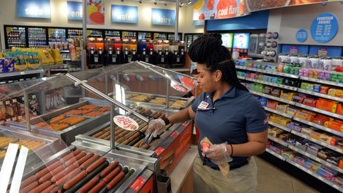 Racetrac employee Jeanique Chestnut stocks the hot food bar at a Smyrna store in February. The metro Atlanta-based company has updated its benefits package with more paid leave for parents.BRANT SANDERLIN / BSANDERLIN@AJC.COM