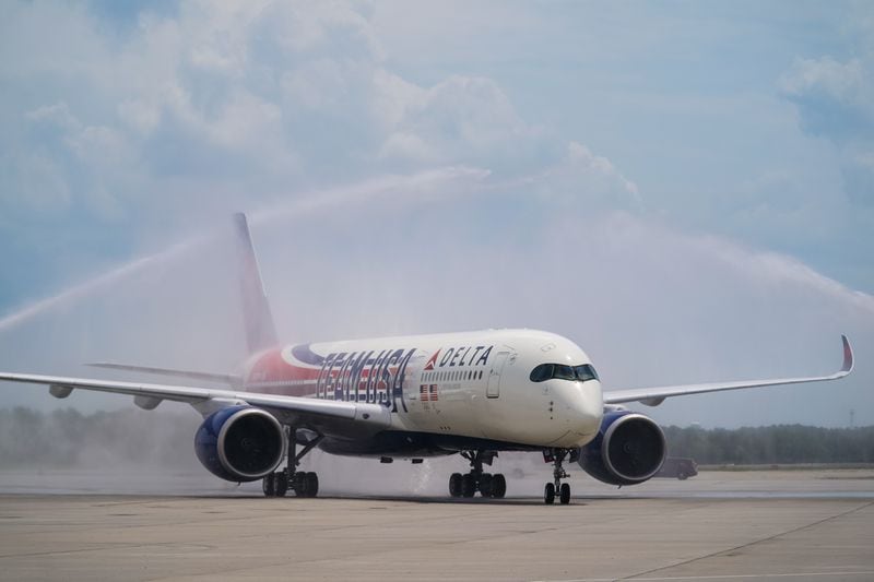 An Airbus A350 decorated in a new Team USA livery celebrating the Paris Olympics receives a water cannon salute as it lands at Hartsfield-Jackson Atlanta International Airport on Friday, May 3, 2024. (Elijah Nouvelage for The Atlanta Journal-Constitution)