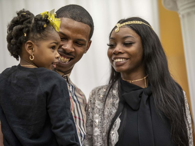 Rashad Hunter, center, and his wife, Kezia Hunter, right, hold their daughter Za’Kari Hunter after being married at the Fulton County Courthouse in Atlanta, Friday, Feb. 12, 2021. (Alyssa Pointer / Alyssa.Pointer@ajc.com)