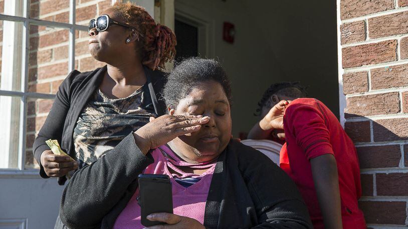 La-Raesha Steward (left) comforts Sonja D. Harrison (center) as she becomes emotional Tuesday while looking at photos of her daughter, Sonja “Star” Harrison, at the Pavilion Place apartments in Atlanta’s Hammond Park community. (ALYSSA POINTER/ALYSSA.POINTER@AJC.COM)