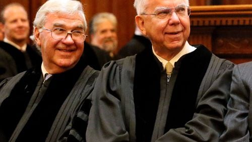 Hugh Thompson (right) chuckles before being sworn in as the Georgia Supreme Court’s chief justice during an Aug. 15, 2013, ceremony in the House chamber of the State Capitol. Justice Harris Hines, who will succeed Thompson as chief, is seated next to him on the left. (Photo: Phil Skinner/AJC file)