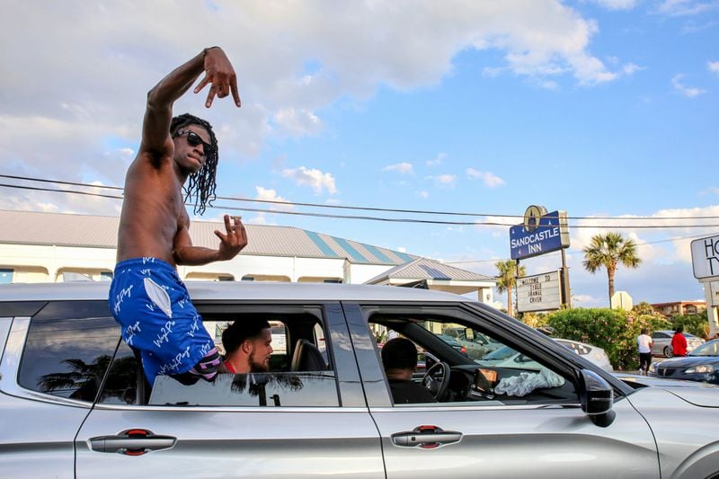 An Orange Crush partygoer leans out of his car's window during stopped traffic on Tybee Island in 2023.