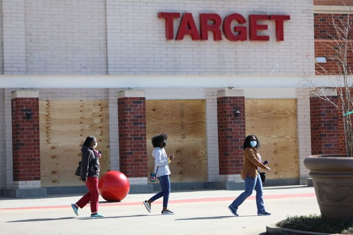 People leaving Target at Edgewood Retail Center shoppers walks in front of protected plywood sheets. Business around town are boarding up windows amid fears of unrest  related to the elections on Tuesday, Nov. 3, 2020, 
Miguel Martinez for The Atlanta Journal-Constitution