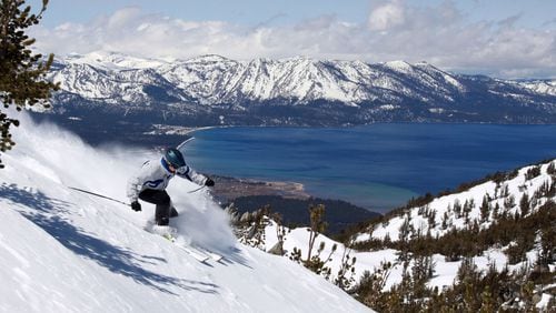 With Lake Tahoe as a backdrop, a skier kicks up some powder at Heavenly Ski Resort in April 2010 in South Lake Tahoe, Calif. (AP Photo/Dino Vournas)
