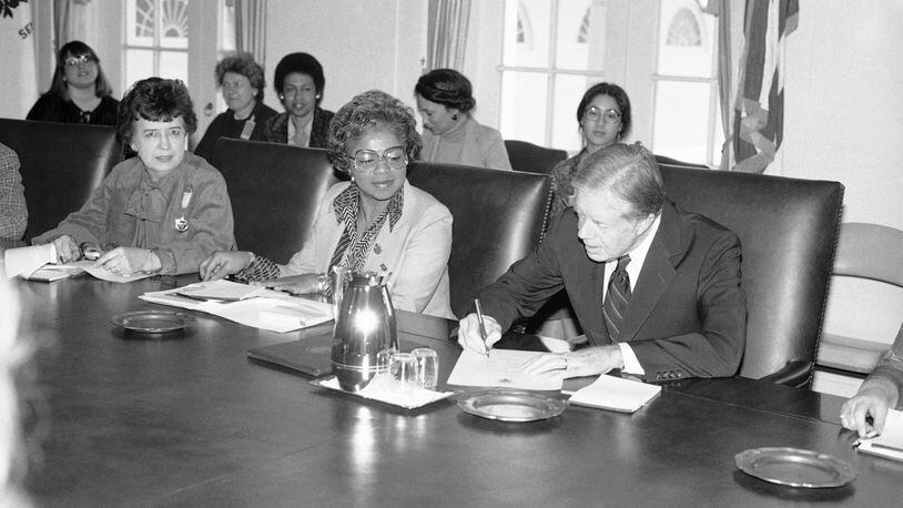 President Jimmy Carter signs document at the White House in Washington on Feb. 28, 1980 proclaiming March 2-8 "National Women’s History Week." To the president’s right are: Jane Pratt, president, Girls’ Clubs of America; and Gloria Johnson, treasurer, Coalition of Labor Union Women. Those in background are unidentified. (AP Photo/Barry Thumma)