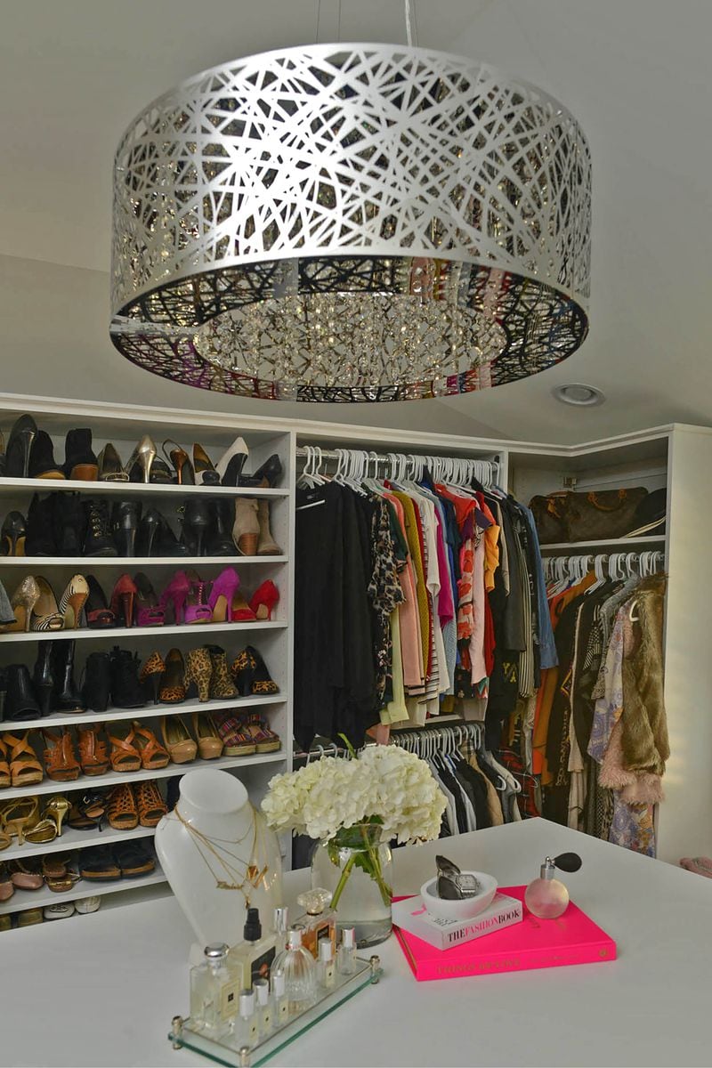 Melissa Bean with 5th Generation Contracting suggested turning a room next the master into a dream closet. Tracy Davis at Creative Closets designed the space, which includes an island that holds an ironing board. Along the top are a few fashion books, perfume bottles and a jewelry bust.