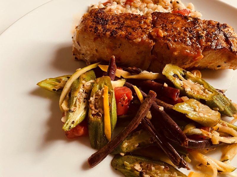 Pan-roasted halibut, served with holy trinity risotto, smoky tomato sauce and a side of sautéed vegetables, is available from Serpas True Food. Bob Townsend for The Atlanta Journal-Constitution
