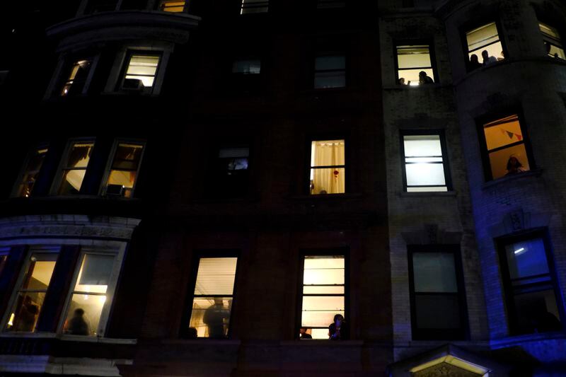 Students watch from their residence hall windows as members of the New York Police Department strategic response team move towards an entrance to Columbia University, Tuesday, April 30, 2024, in New York. After entering the campus, a contingent of police officers approached Hamilton Hall, the administration building that student protesters began occupying in the morning. (AP Photo/Julius Motal)