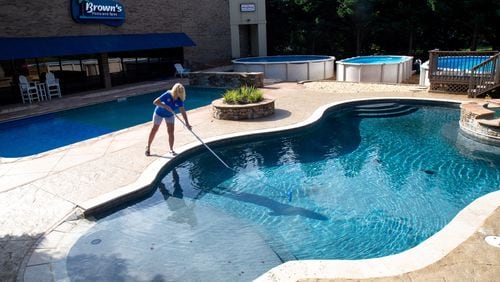 Brown's Pools employee Penny Isbell cleans one of their display pools at their Dallas, Georgia, location July 31, 2020.  STEVE SCHAEFER FOR THE ATLANTA JOURNAL-CONSTITUTION