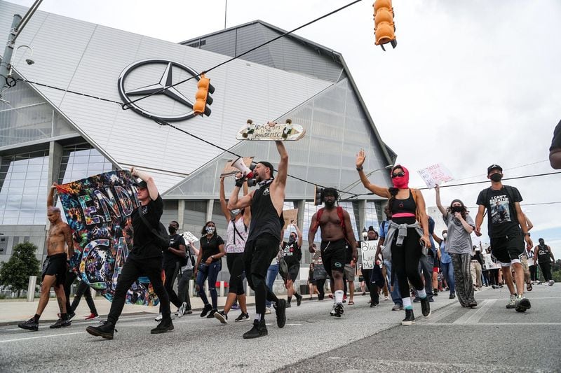A group of protesters march along Northside Drive, passing Mercedes-Benz Stadium, during the 11th day of protests in Atlanta. (Photo: Alyssa Pointer/AJC)