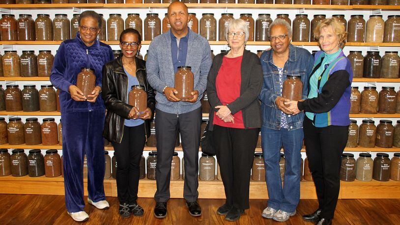 The author, Karen Branan, third from right, with Equal Justice Initiative director Bryan Stevenson and, from left, Jackie Jordan Irvine, Angela Jordan Davis, Jennifer Jordan and Branan’s sister, Barbara Williams. They are holding jars of soil taken from the sites of lynchings. (Deborah Daniels Dawson / for the AJC)