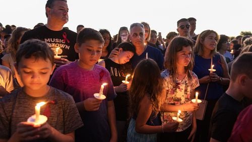 People attend a candlelit memorial service for the victims of the shooting at Marjory Stoneman Douglas High School that killed 17 people on February 15, 2018 in Parkland, Florida. (Greg Lovett / The Palm Beach Post)
