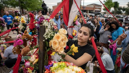 Jessel Paredes, 16, places flowers Sunday on a memorial outside the Allen Premium Outlets in suburban Dallas, where, a day before, a gunman killed eight. The shooter's social media posts indicate that he had staked out the mall using Google to determine the busiest times. CREDIT: The Washington Post by Jeffrey McWhorter
