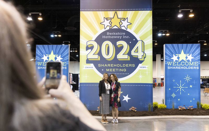 From left, D'Ann Rhoten takes a photo of Brittany Thornton and Melissa Shapiro in the exhibit hall of the Berkshire Hathaway annual meeting on Saturday, May 4, 2024, in Omaha, Neb. (AP Photo/Rebecca S. Gratz)