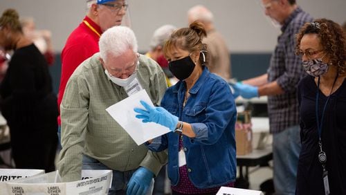 Cobb County election staff check ballots during the recount of the presidential ballots on Nov. 13. Georgia began its third tally in the presidential race Tuesday. (Steve Schaefer/Atlanta Journal-Constitution/TNS)