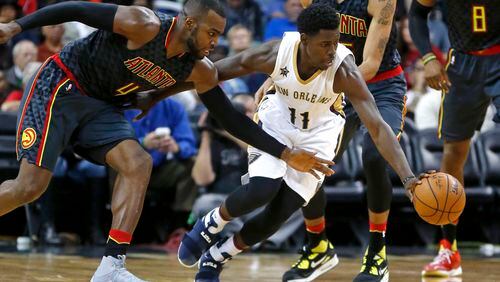 New Orleans Pelicans guard Jrue Holiday (11) and Atlanta Hawks forward Paul Millsap (4) chase a loose ball in the second half of an NBA basketball game in New Orleans, Thursday, Jan. 5, 2017. The Hawks won 99-94. (AP Photo/Gerald Herbert)