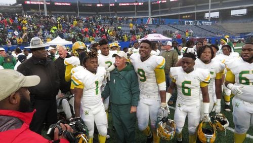 Dublin coach Roger Holmes is surrounded by Fighting Irish players following their 42-32 win over the Brooks County Trojans in the Class AA championship game on Friday, Dec. 13, 2019 at Georgia State Stadium. (Adam Krohn)