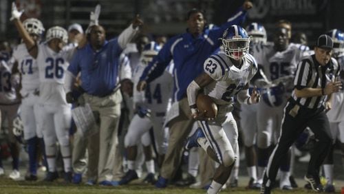 Peachtree Ridge’s Chad Clay runs back an interception as his team reacts against North Gwinnett. (TAMI CHAPPELL/SPECIAL TO THE AJC)