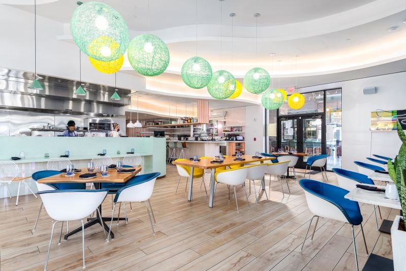 Pastel colors and bulbous paper lantern lights lend an inviting feel to Juniper Cafe's dining room.  Courtesy of Eric Sun