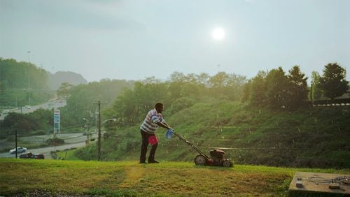 Paul Graham’s “Pittsburgh (detail)” captures the typically overlooked effort of a man mowing the grass on a steep hillside at a generic highway exit of cheap motels and gas stations. COPYRIGHT PAUL GRAHAM / CONTRIBUTED BY PACE/MACGILL GALLERY, NEW YORK