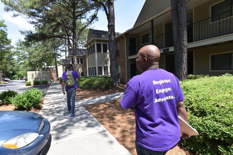 Corbin Spencer (foreground), field director of New Georgia Project, and Rodney King, volunteer, walk through a neighborhood to canvass registering voters for the District 6 runoff on Wednesday, May 17, 2017. The rush is on to register voters in Georgia’s 6th district, following a judge’s decision to reopen registration as part of a lawsuit against the state. It’s the latest in a series of lawsuits and street-level actions by liberal groups and civil rights organizations like the NAACP and the ACLU to push for more open access to the ballot box. HYOSUB SHIN / HSHIN@AJC.COM