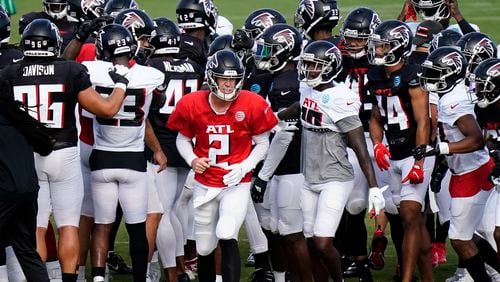 Falcons QB Matt Ryan congregates with teammates during a brief break in the action Wednesday during training camp practice. (Brynn Anderson/AP)