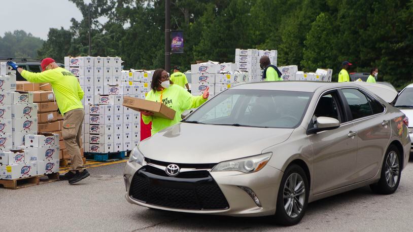 Volunteers load cars with boxes of food during a food giveaway event at Berean Christian Church on Saturday, August 27, 2022, in Stone Mountain. Boxes handed out in DeKalb County included Georgia-grown fruits and vegetables, eggs and 10-pound bags of chicken. CHRISTINA MATACOTTA FOR THE ATLANTA JOURNAL-CONSTITUTION.