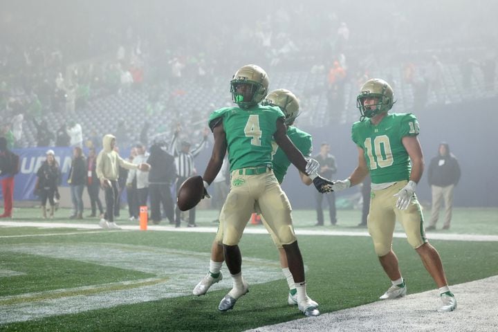 Buford wide receiver Tobi Olawole (4) celebrates with teammates after he made a go-ahead touchdown catch against Langston Hughes during the fourth quarter of the Class 6A state title football game at Georgia State Center Parc Stadium Friday, December 10, 2021, Atlanta. JASON GETZ FOR THE ATLANTA JOURNAL-CONSTITUTION